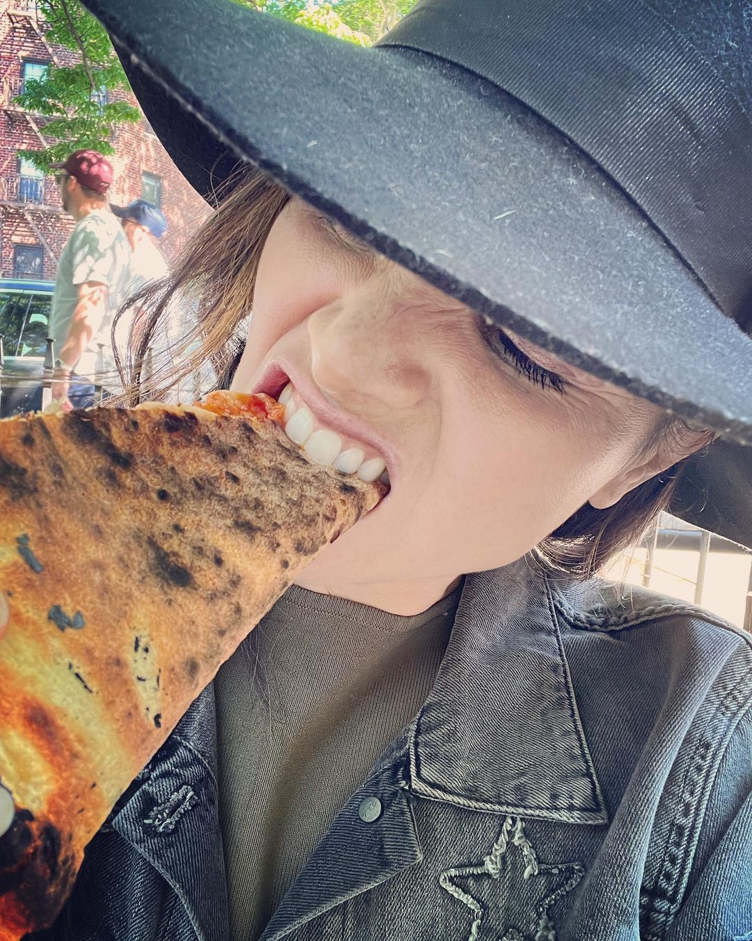 Katrina Law taking a bite of a pizza slice.