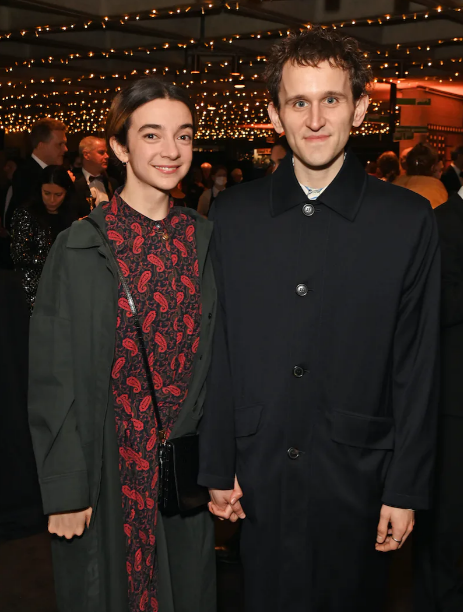 Harry Melling and Patsy Ferran holding hands at a benefit event at the National Theatre in March 2022. 