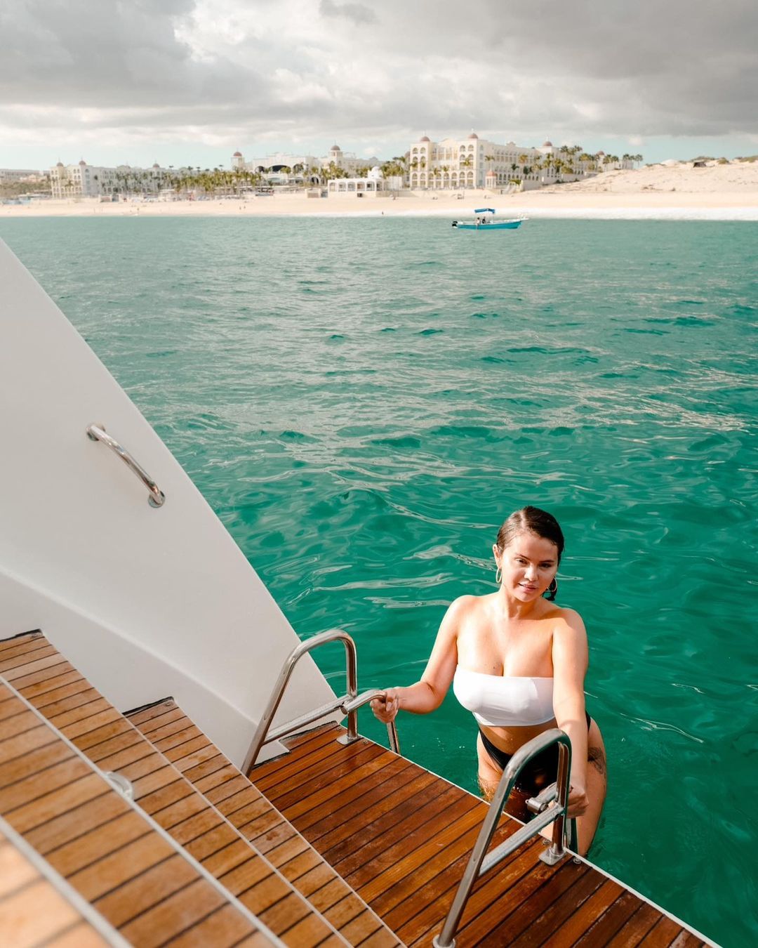 Selena Gomez climbing into the yacht after swimming