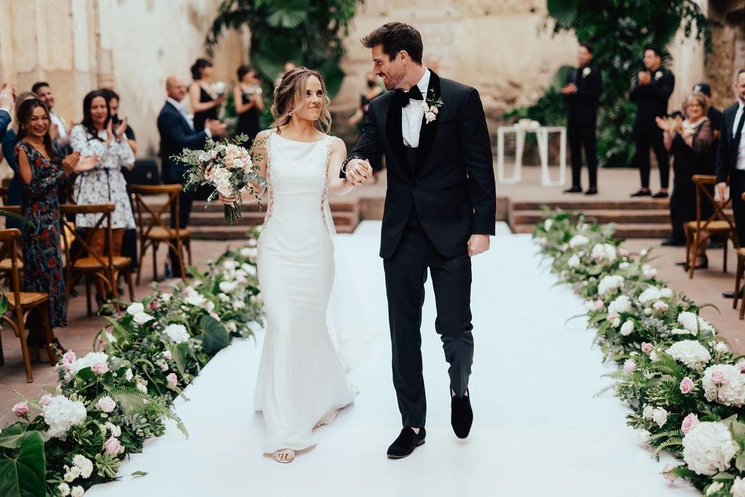 Marcus Rosner walking down the aisle with his wife, Ali Kroeker, at their wedding