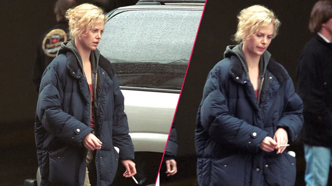 Charlize Theron smoking a cigarette as she walks by a vehicle