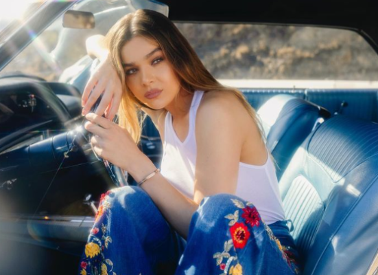 Hailee Steinfeld poses in a car 
