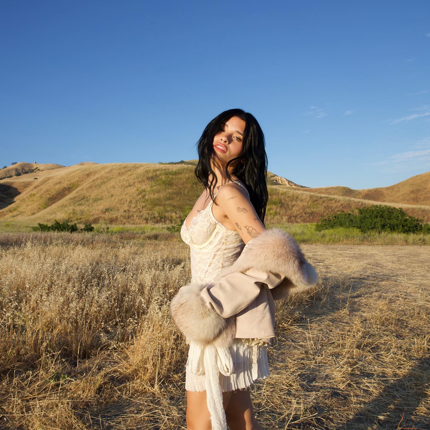 Nessa Barrett dressed in white at the location for her 'Die First' music video