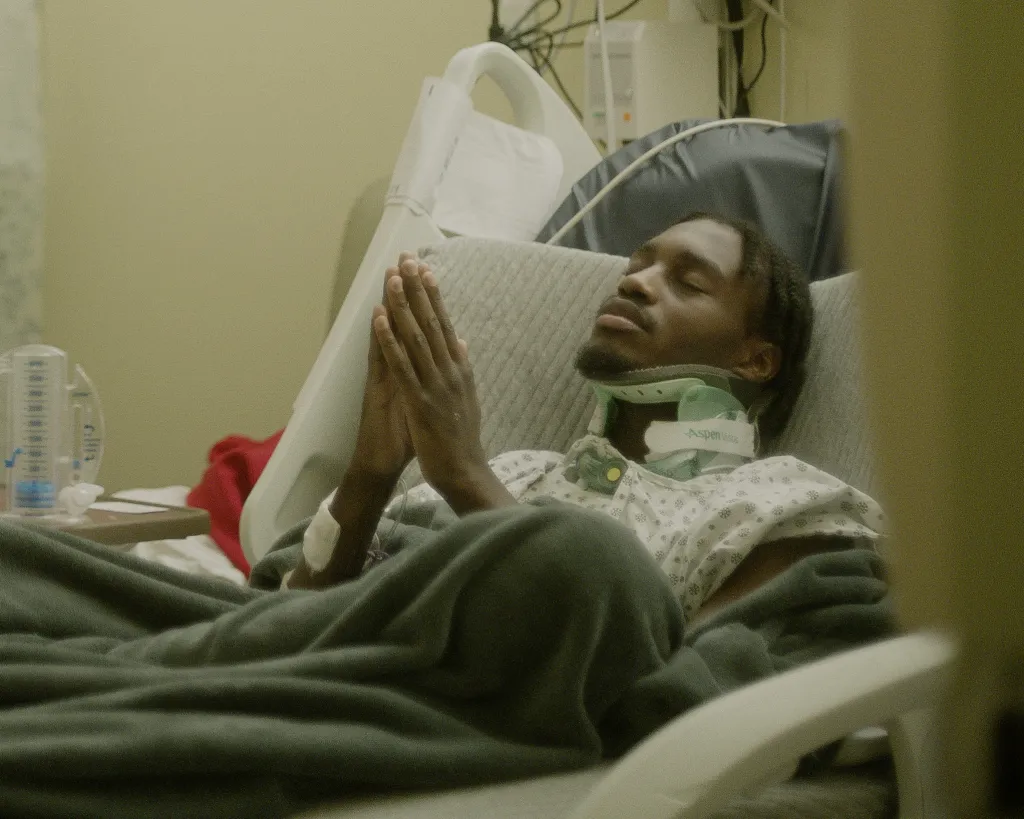 Lil Tjay praying while lying in a hospital bed after being fatally shot