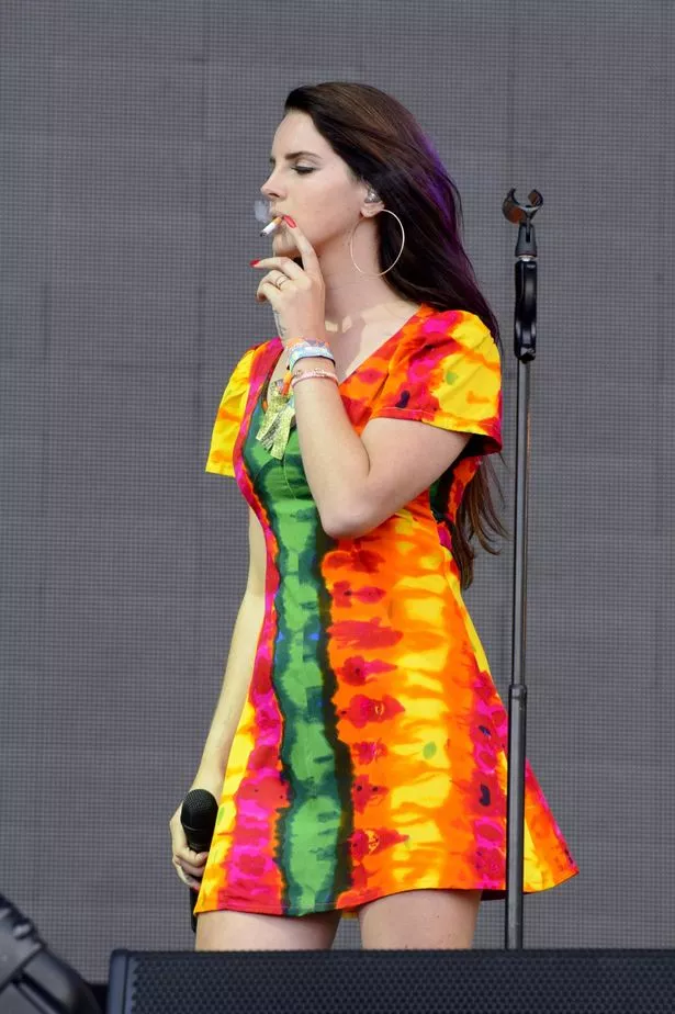 Lana Del Rey smoking a cigarette on stage during her show in Glastonbury