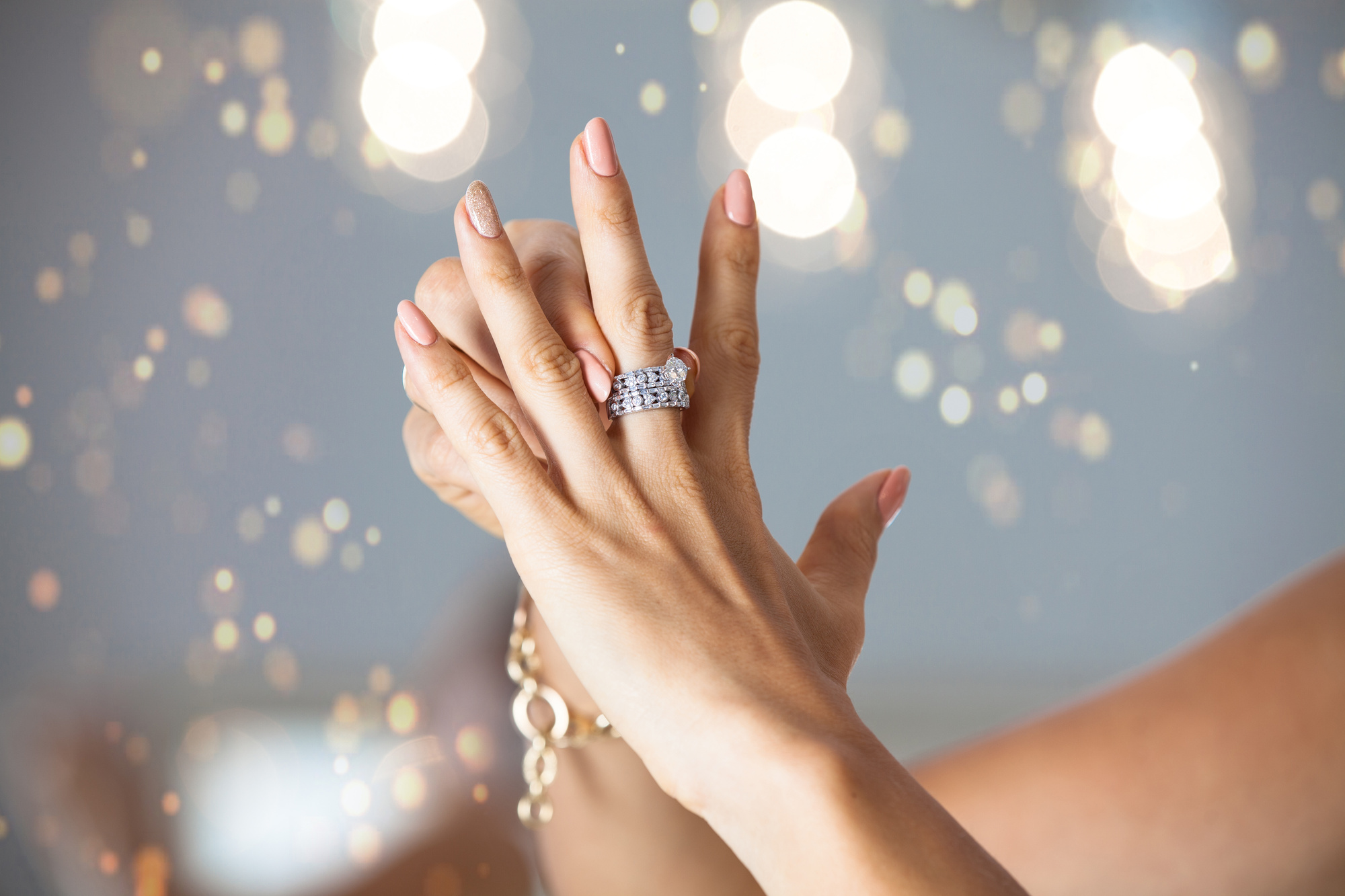 Closeup photo of a beautiful female hands with elegant manicure and diamond rings. Holidays and celebration concept.