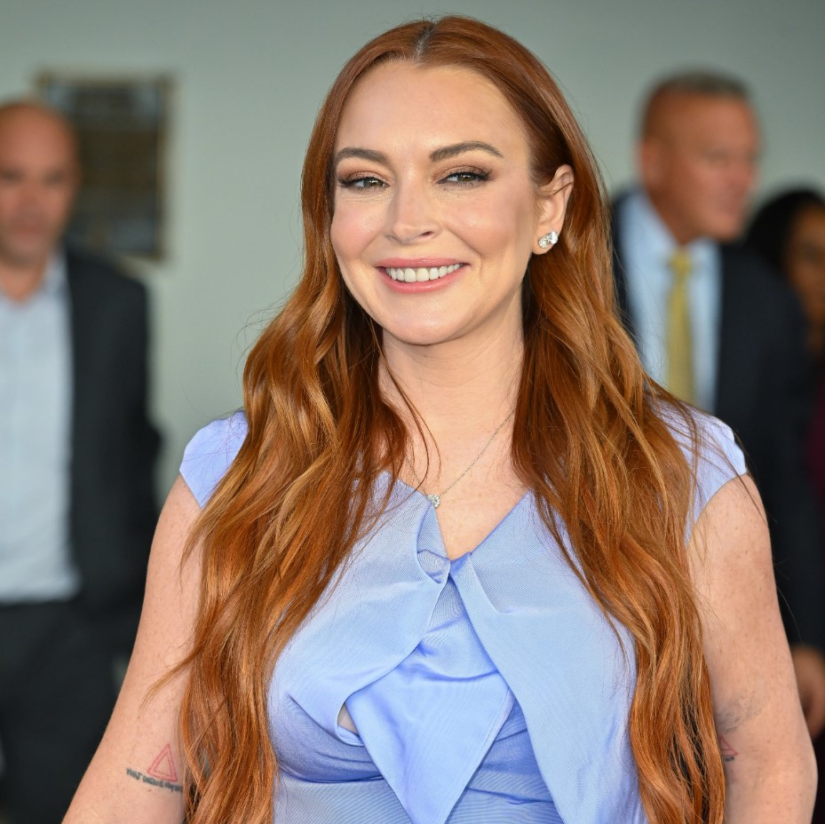Lindsay Lohan smiling, with her fixed teeth visible, in December 2022